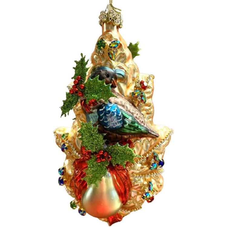 Blown glass ornament of a Partridge and a pear with a red ribbon, on a gold fir tree branch with jewel embellishments.