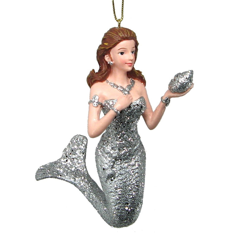 Mermaid with brown hair dressed in all sivler holding out a silver shell. Gold hanger from top.