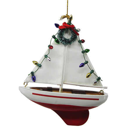 white sailboat with red hull & Christmas lights & wreath on it