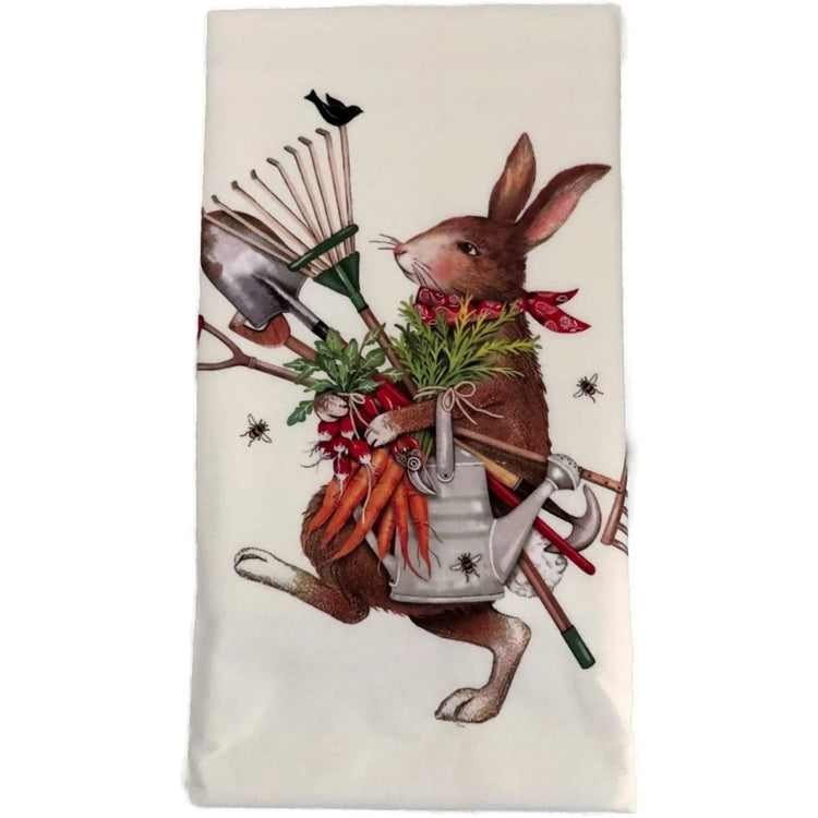 white flower sack towel with a brown rabbit in a red bandana carrying garden tools, watering can, and fresh vegetables.