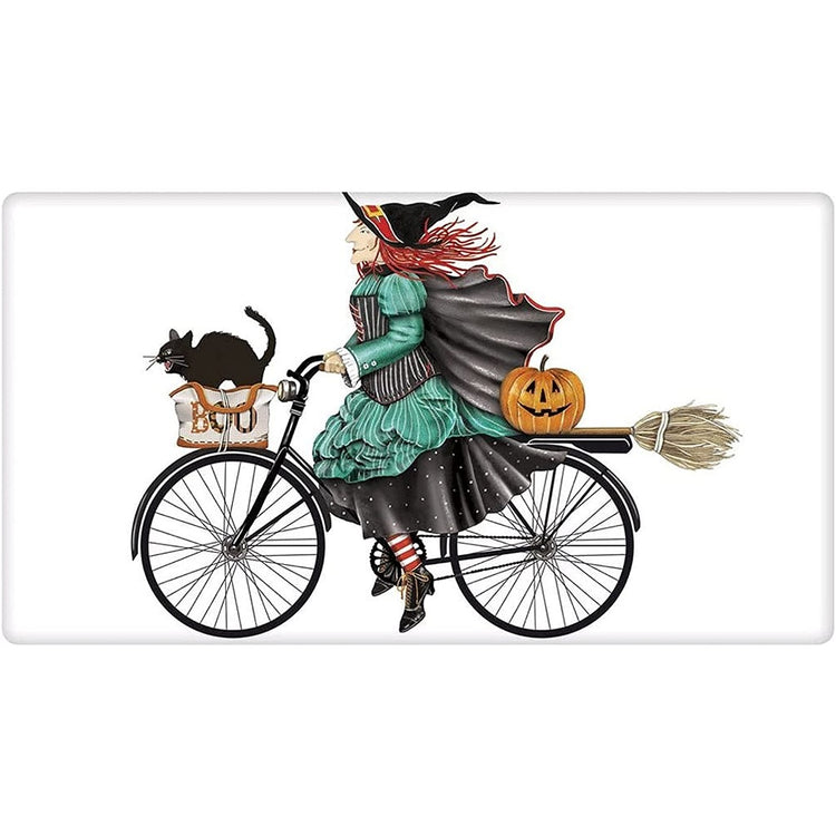 Witch with red hair on a black bike with a cat, pumpkin & green dress.