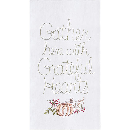 White embroidered towel saying "gather here with grateful hearts" & a pumpkin.