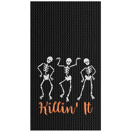 Black waffle weave dishtowel with white embroidered skeletons and orange embroidered words "Killin' It"