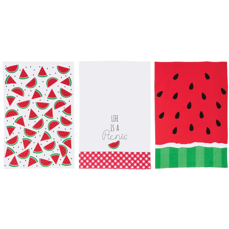 3 towels, 1 has watermelon slices, one is red and green like a watermelon and the other says Life is a Picnic.