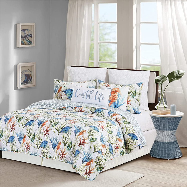White quilt with blue, green & orange crabs, coral & seahorses.