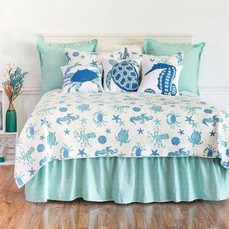 White quilt with blue octopus, seahorse, crab & starfish on it.