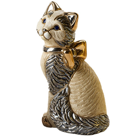 Cat shaped figurine gazing up.  Bold with black accent wearing a gold bow.  Lots of texture.