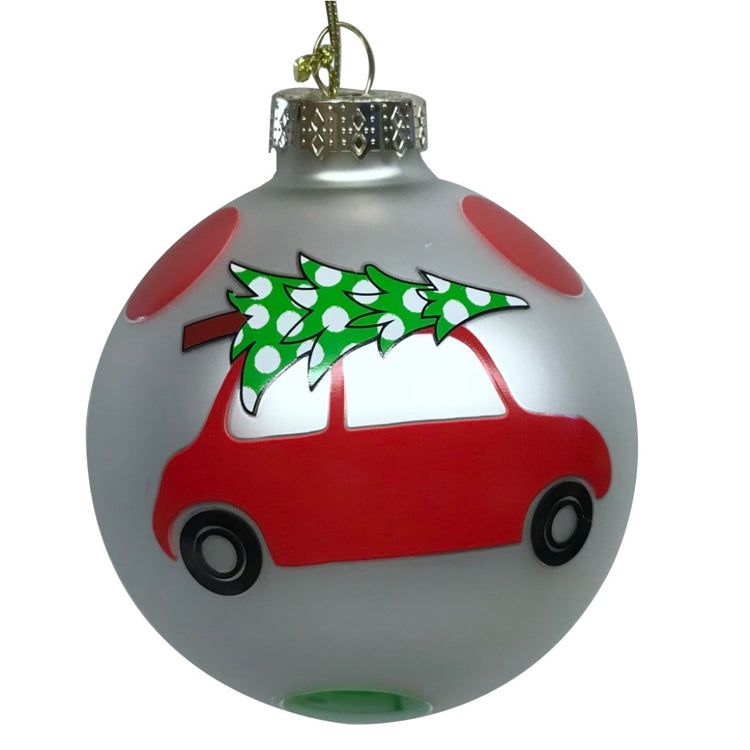 Iridescent round Christmas ornament with red car carrying a Christmas tree on top.