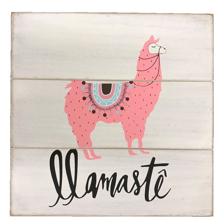 3 white plank wood with a pink llama with a teal saddle on and 'llamaste' underneath. 