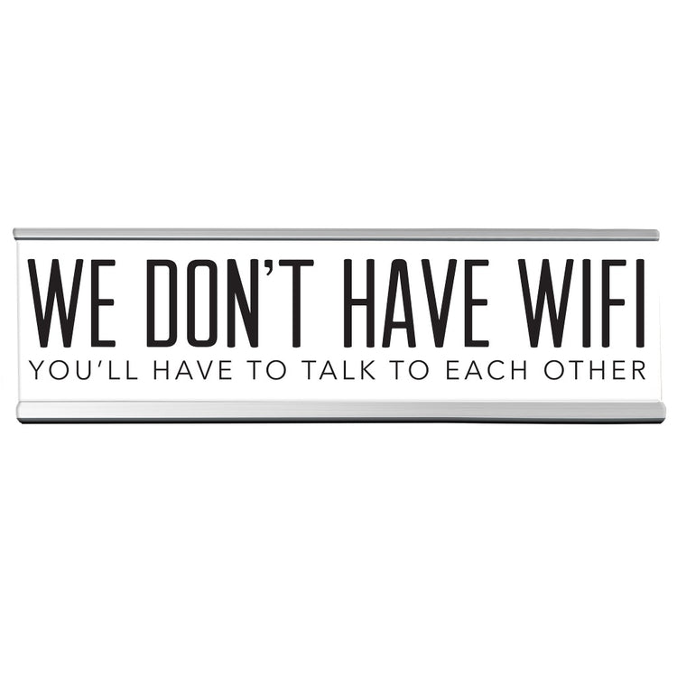 Name plate type sign in white with black lettering "WE DON'T HAVE WIFI YOU'LL HAVE TO TALK TO EACH OTHER".