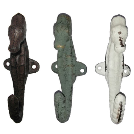 3 cast iron seahorse shaped wall hooks. 1 is white, 1 is sea foam green, 1 is brown, all look weathered.