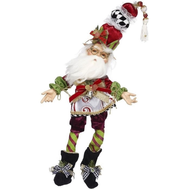 White elf with a white beard in glasses & Christmas outfit & hat on.