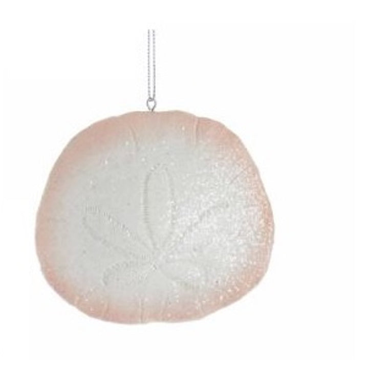 White sand dollar with a pink tint around the outside and glitter.