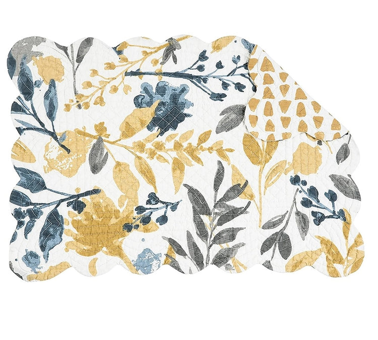 White quilted rectangular placemat with blue, mustard yellow and grey floral designs.