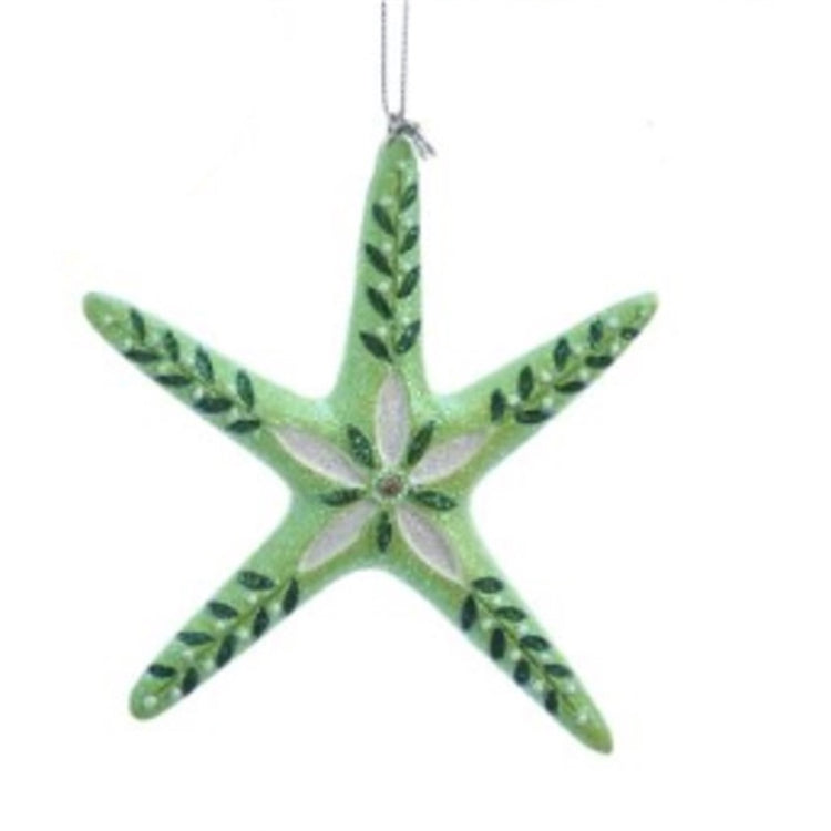 Thin green starfish ornament with dark green leaves in each leg. White & dark green flower in middle.