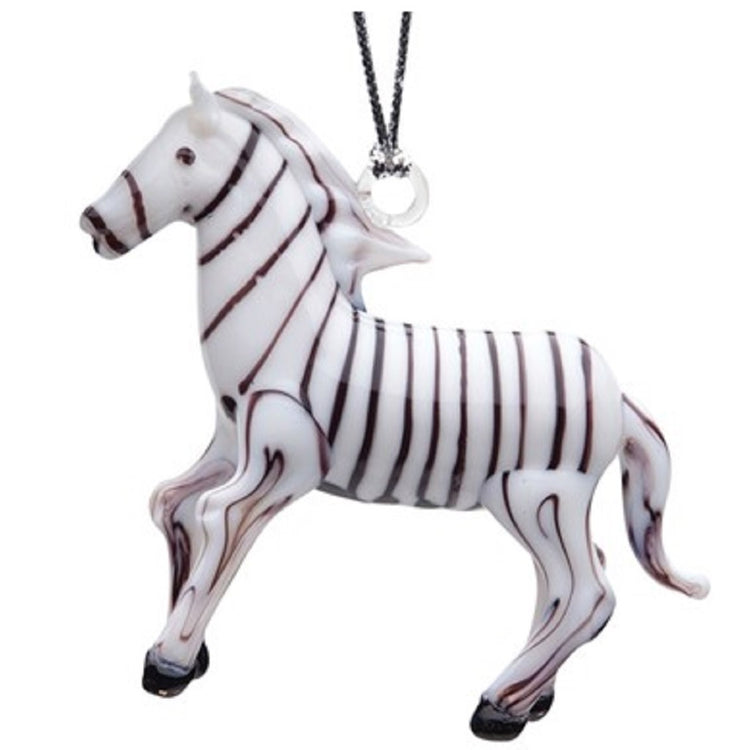 Glass standing zebra, white with brown stripes on entire ornament. Hooves and eye are brown. Hanger attached to mane.