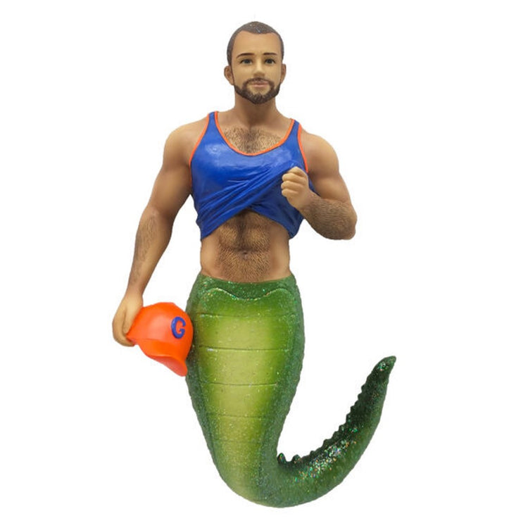 Resin merman ornament, his tail is that of an alligator, he's wearing a blue and orange tank top and holding an orange cap with a blue G.