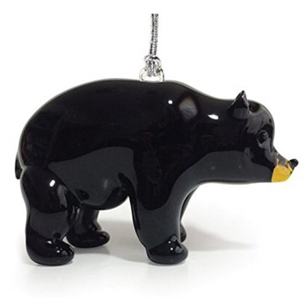 Glass bear ornament standing on all 4 feet. Bear is black except for yellow around snout & mouth. Hanger attached to back.