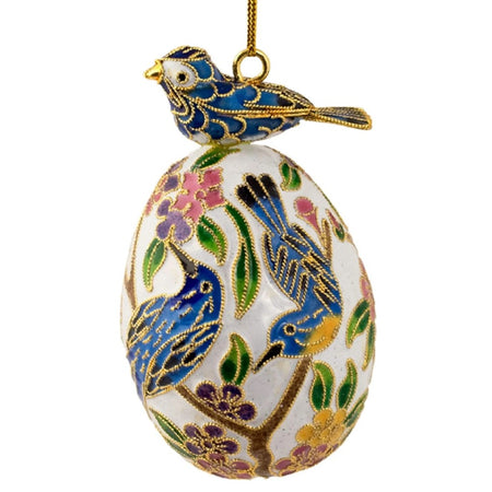 cloisonne egg ornament with blue bird sitting on top. The egg has blue birds and flowers painted on it.