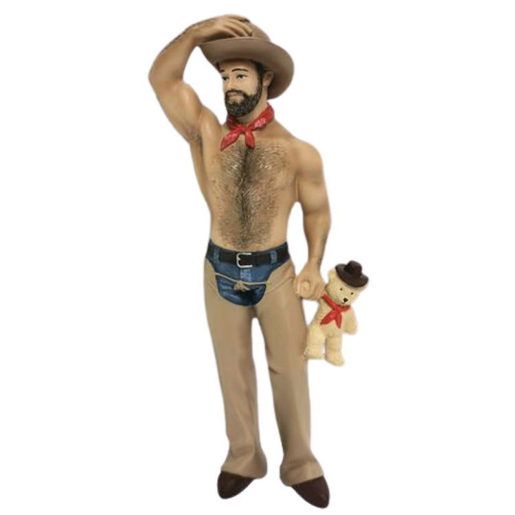 Shirtless man in jeans with chaps, cowboy hat, and red bandana around his neck, he's holding a teddy bear in a matching outfit.