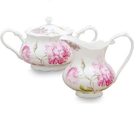 1 creamer pitcher and 1 covered sugar bowl. Sugar bowl has 2 handles and both are cream to white color with pink dahlia design.