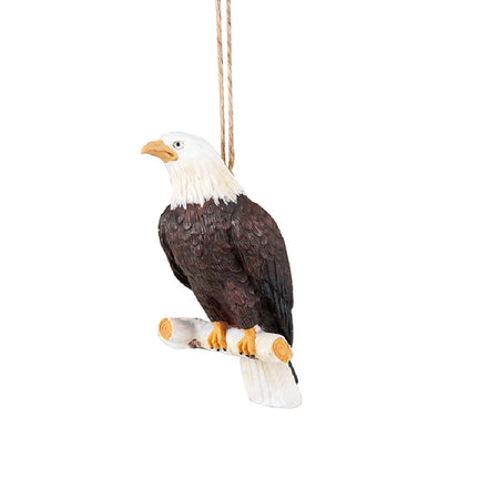 Hanging resin ornament shaped like a bald eagle, sitting on a white tree branch.