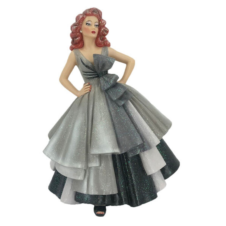 Drag Queen figurine with red wavy hair wearing a grey, white and black fancy dress with large bow