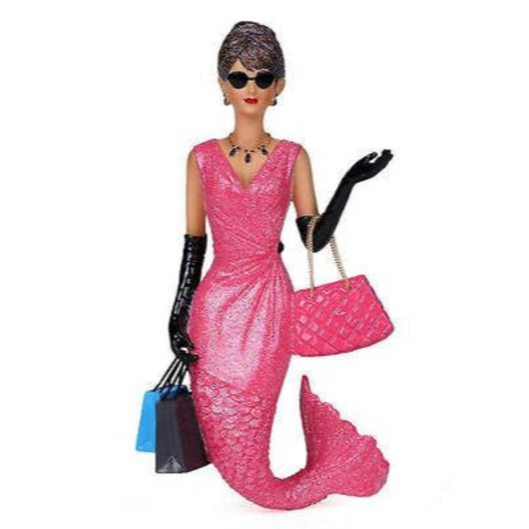Mermaid shaped figurine hanging ornament.  Pink outfit, black gloves, dark sunglasses she is holding 2 shopping bags.