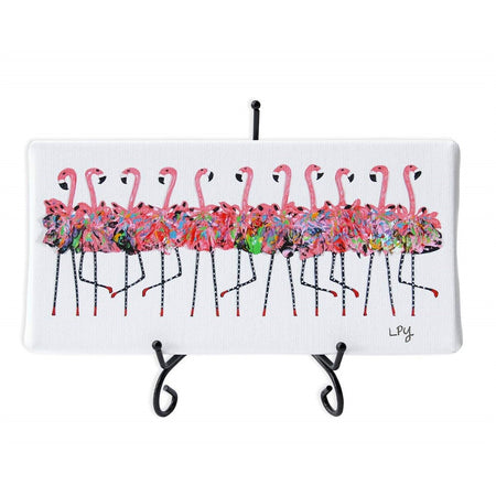 White rectangle canvas on black wire stand.  Shows 11 flamingos wearing tutu's dancing in a chorus line.