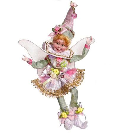 fairy girl figure. She wears glittery long sleeve and tights with a white frilly dress over.  White wings and a pointy hat that matches her dress.  Pink accents and yellow roses.