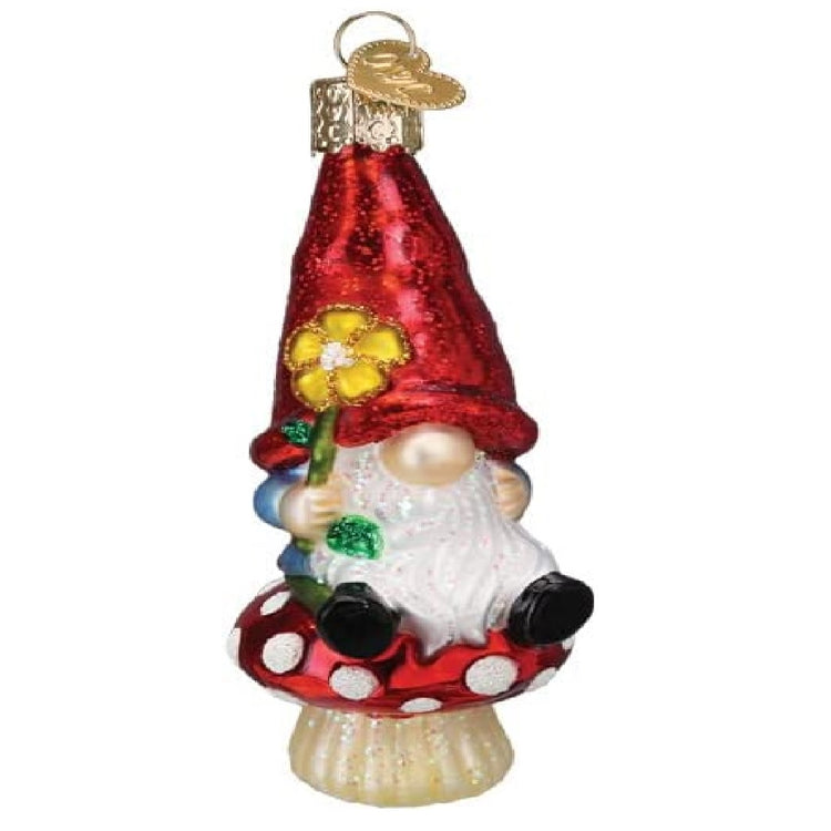 Blown glass ornament of a gnome in a red hat sitting on a mushroom.