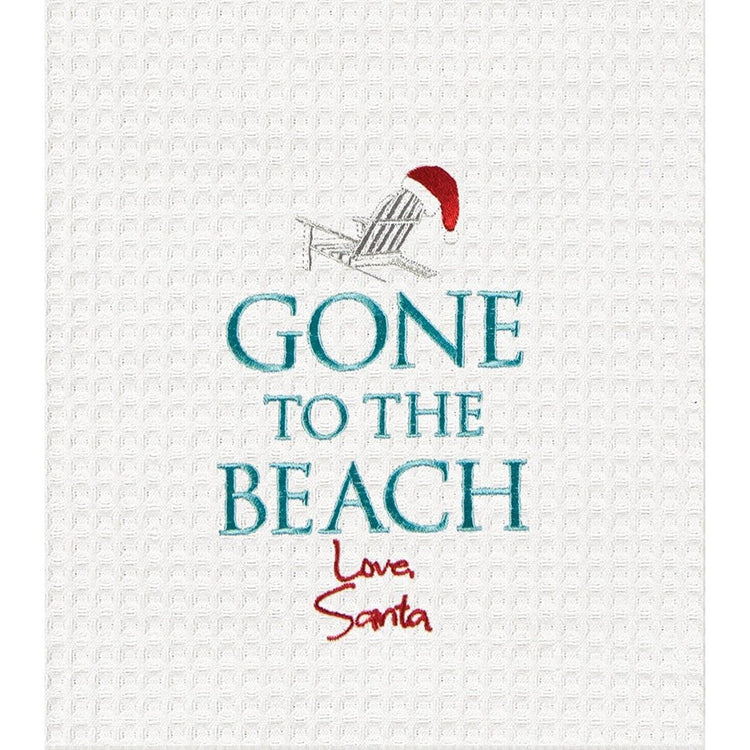White towel, adirondack chair with santa hat on top. Text "Gone to the Beach" under that signature looking text "Love Santa"