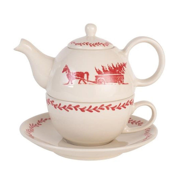Off white tea for one with saucer.  Red horse and carriage carrying a tree.