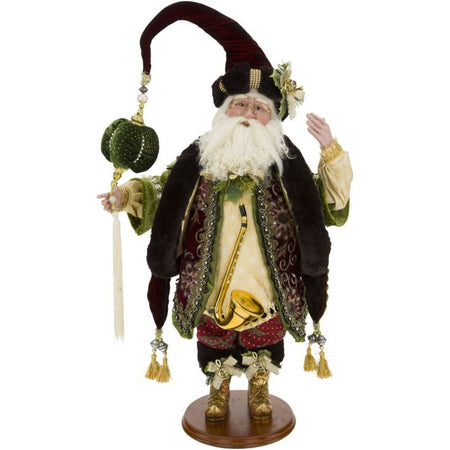 Santa figure on stand wearing maroon coat with scarf and elaborate hat.