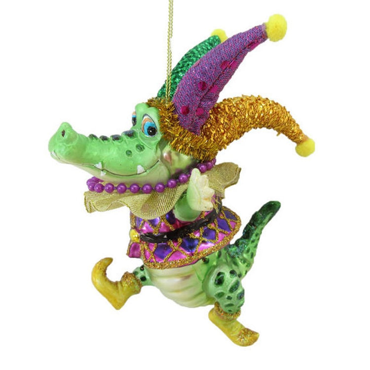 Jester cartoon alligator smiling and wearing a yellow, green, and purple Mardi Graw costume.