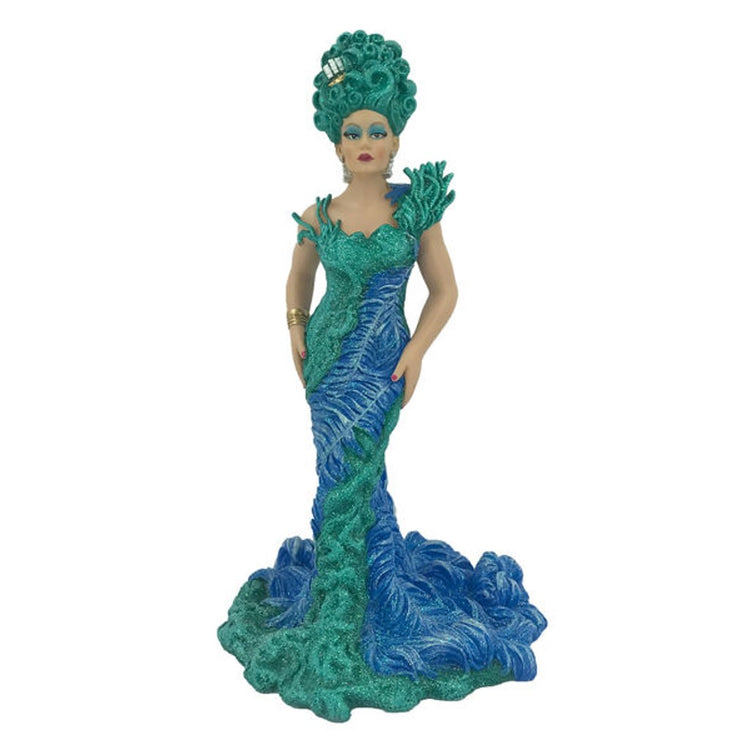 Drag queen figurine teal hair, wearing floor length teal and blue dress. Has hands on hips