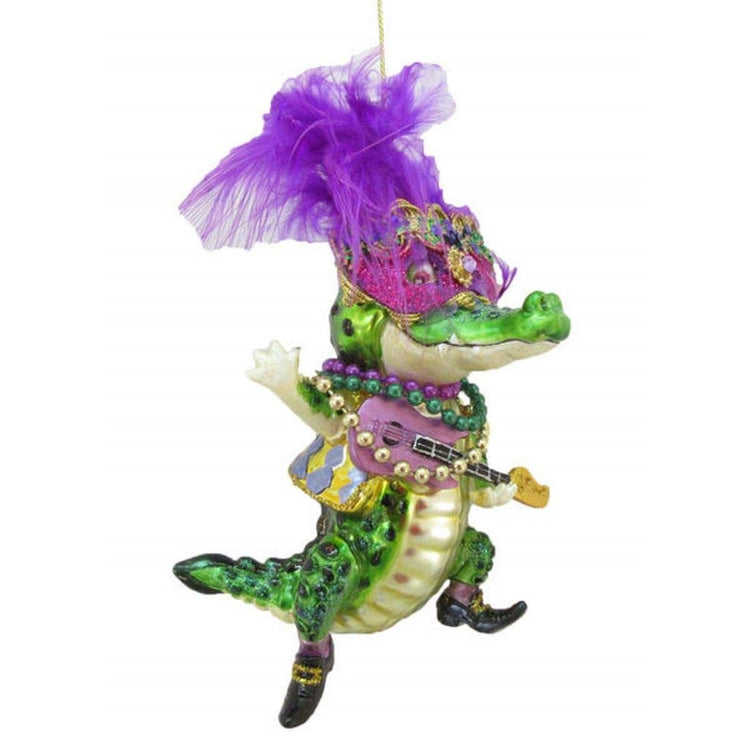 Male crocodile figurine ornament in gold and green holding a guitar with Mardi Gras beads.