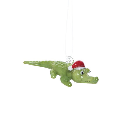 Green alligator with a Santa hat on.