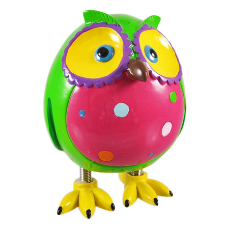 Owl standing on spring legs. Body green, pink belly with spots, yellow feet and ring around eyes. Beak is brown