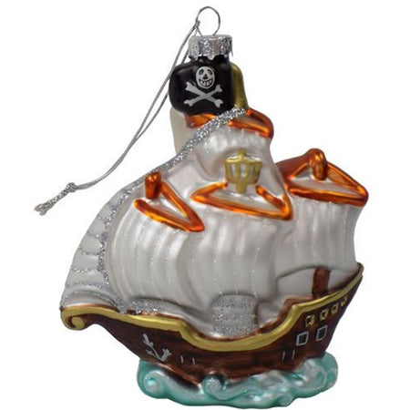 Pirate ship shaped hanging Christmas ornament shown sailing on water with skull and crossbone flag.