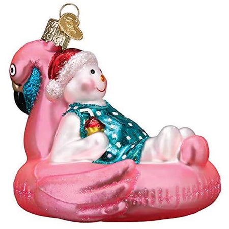 Blown glass ornament of snowman in a blue swim suit lounging on a flamingo shaped pool floatie.