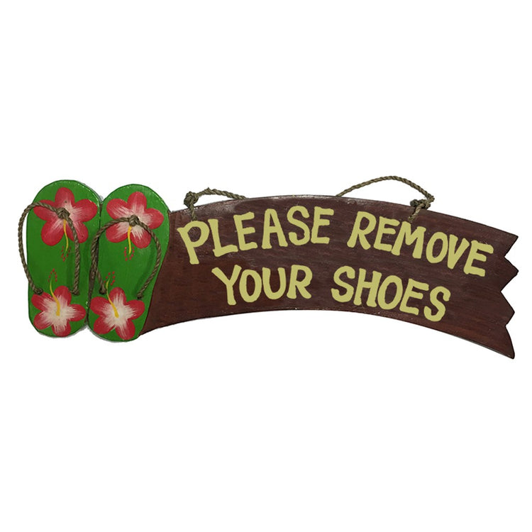 Brown wood sign with green flip flops with pink & white hibiscus. Saying 'please remove your shoes'.
