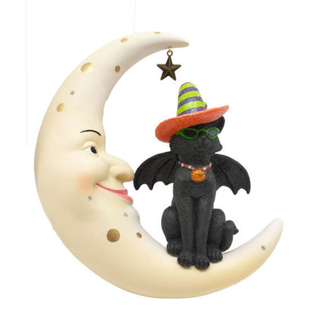 Black cat with bat wings sitting on a crescent moon. Cat has orange collar and a witches hat with green and purple stripes and an orange brim.