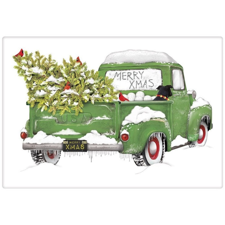 White towel, green truck view from behind. text "Merry Xmas" is written in snow on back window. Dog & tree in truck bed.