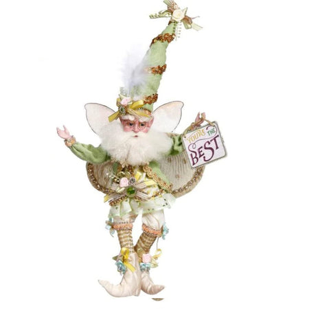 fairy figurine.  he wars white knee length shorts and white boots. he has white wings and a green long sleeve shirt. He has a tall pointy hat in green. Carries a sign that says "you're the best.
